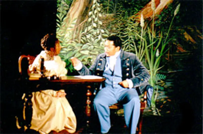 Two performers seated at a table in a scene from Toby’s My Brother & Beethoven Too